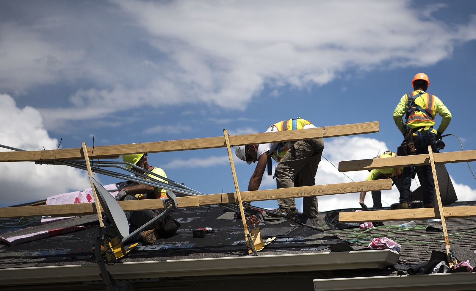 Roofer nailing shingles on a residential roof