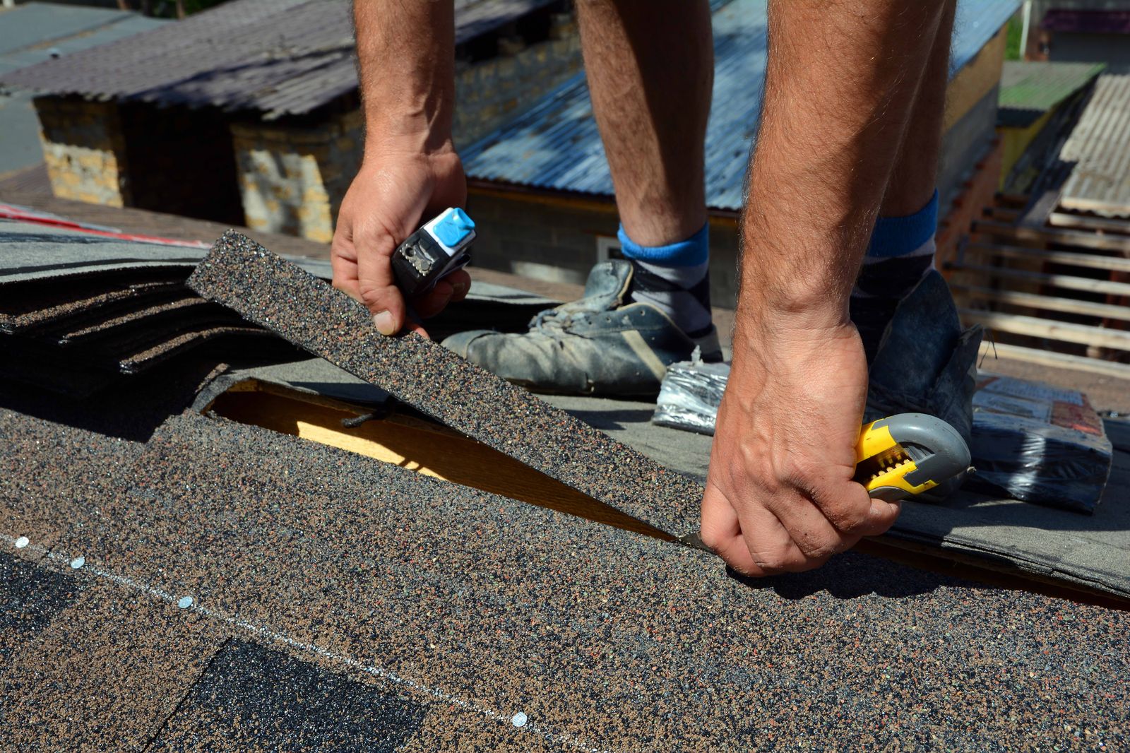 Roofer laying shingles in rows on a pitched roof